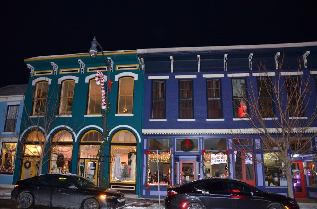 Colorful buildings line a street at night.