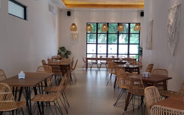 A restaurant with wicker tables and chairs — Hazelnut Kitchen