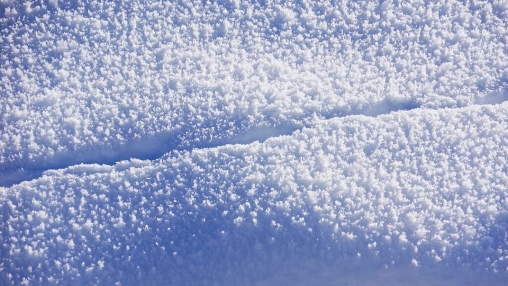 Close-up of textured snow with a clear line.