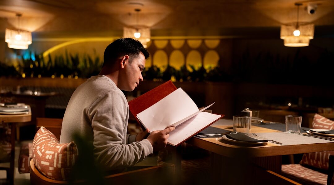 Man reading a menu at a restaurant table. — Boomtown Kitchen