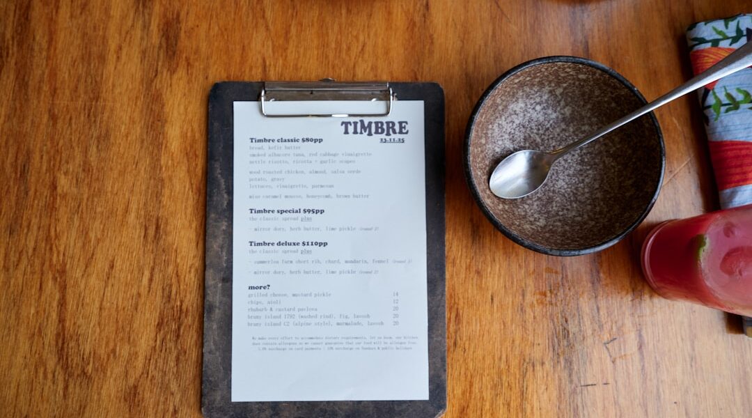 Menu on a wooden table with food items. — Stonecat Café