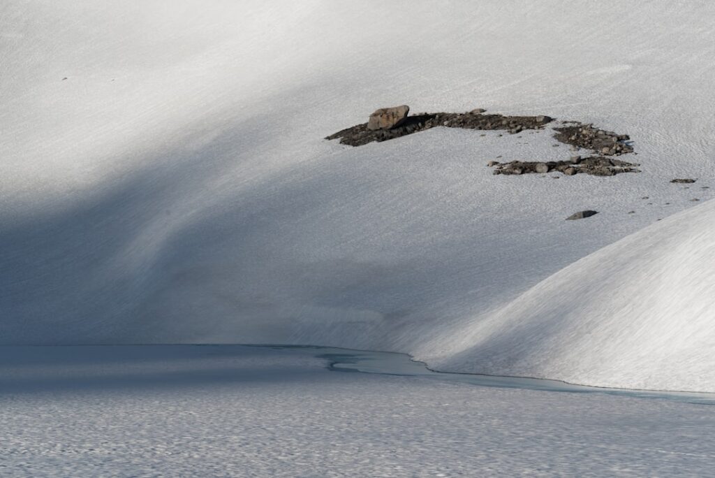 A snowboarder is going down a snowy hill