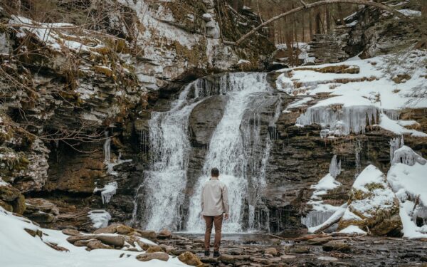 A person standing in front of a waterfall — Cayuga Lake Wine Trail: The Complete Tasting Guide