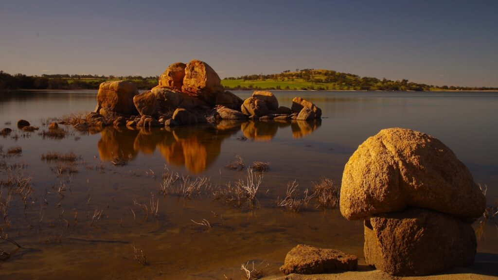 A large rock sitting on top of a body of water
