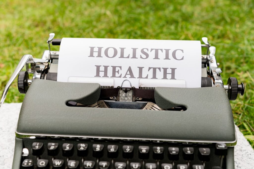 A close up of a typewriter with a paper that says holstic health