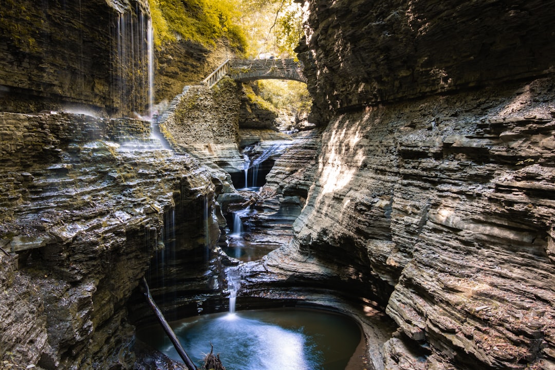Water falls between brown rock formation during daytime — Things to Do in Watkins Glen Beyond the Gorge