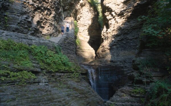 People walking on a path between rocky cliffs — Watkins Glen Gorge Trail: What to Know Before You Go