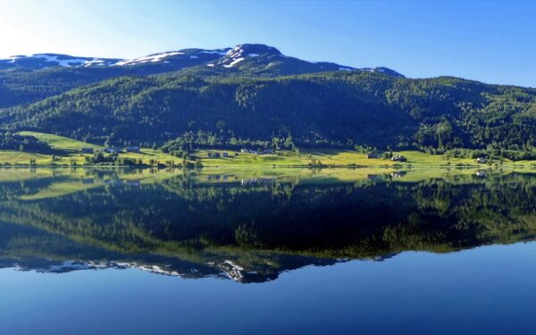 Green grass field near lake during daytime — Where to Stay in the Finger Lakes: Picking the Right Town as Your Base